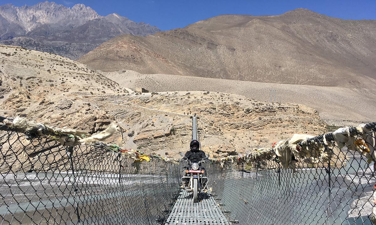 A rider crossing a suspension bridge near Kagbeni, below Muktinath.